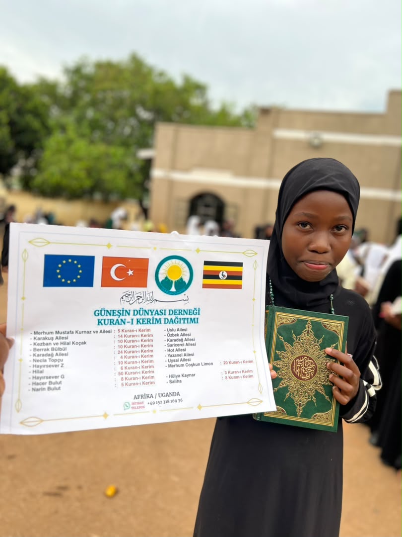 Mädchen mit einem Koranexemplar nach der Ausgabe in Uganda