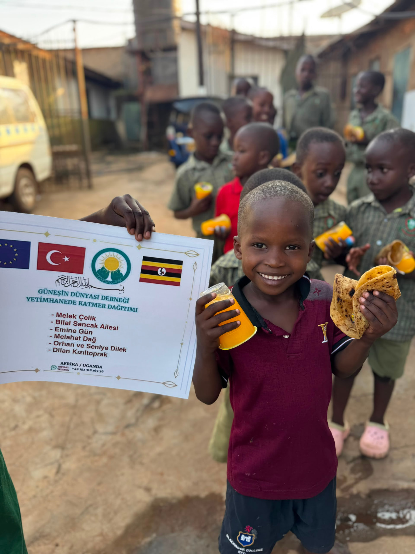 Kind mit Fladenbrot und Getränk in Uganda