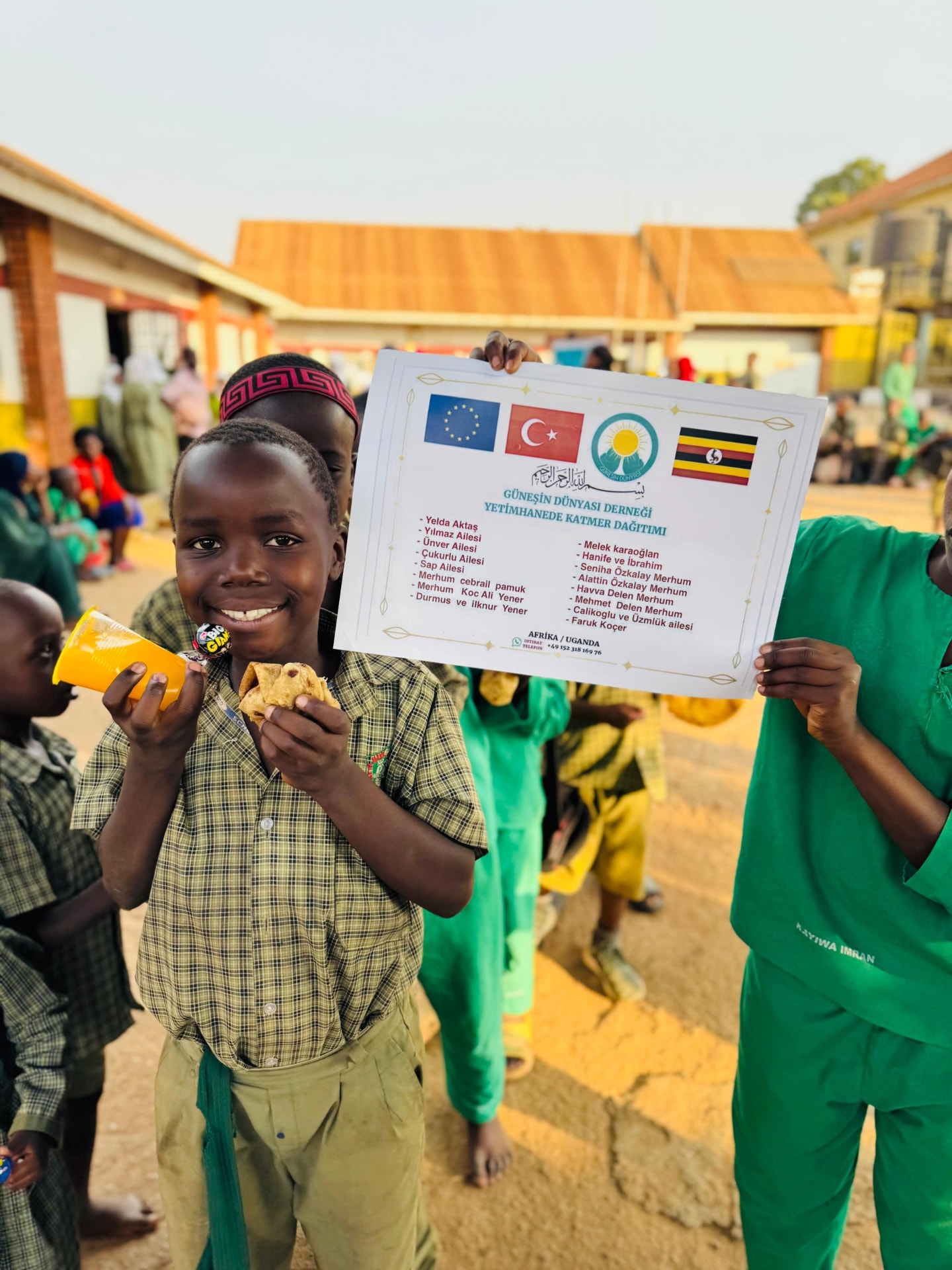 Kind mit einer Mahlzeit und einem Getränk bei der Ausgabe in Uganda